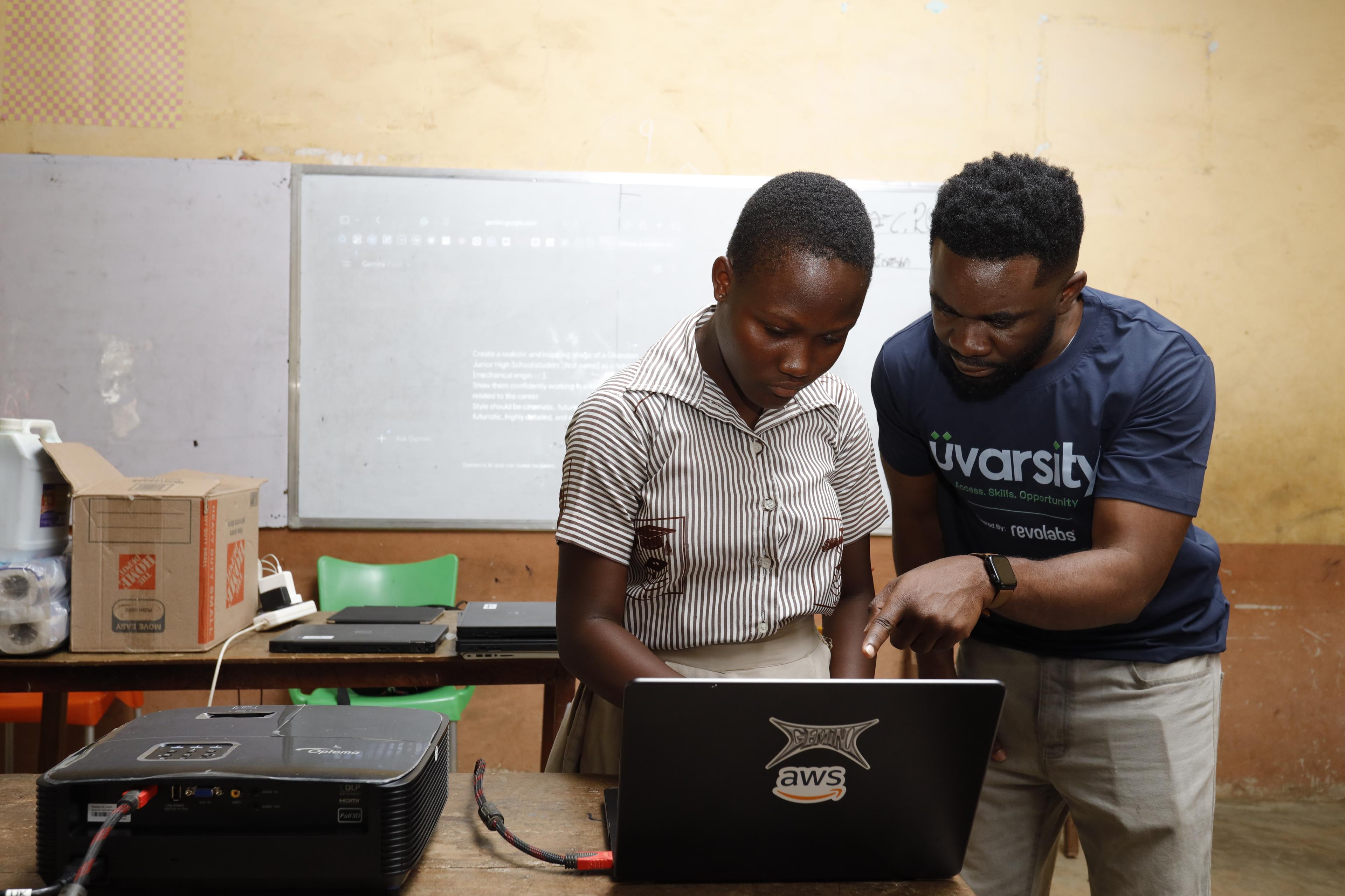 Mentor guiding a student on a laptop during an AI literacy session